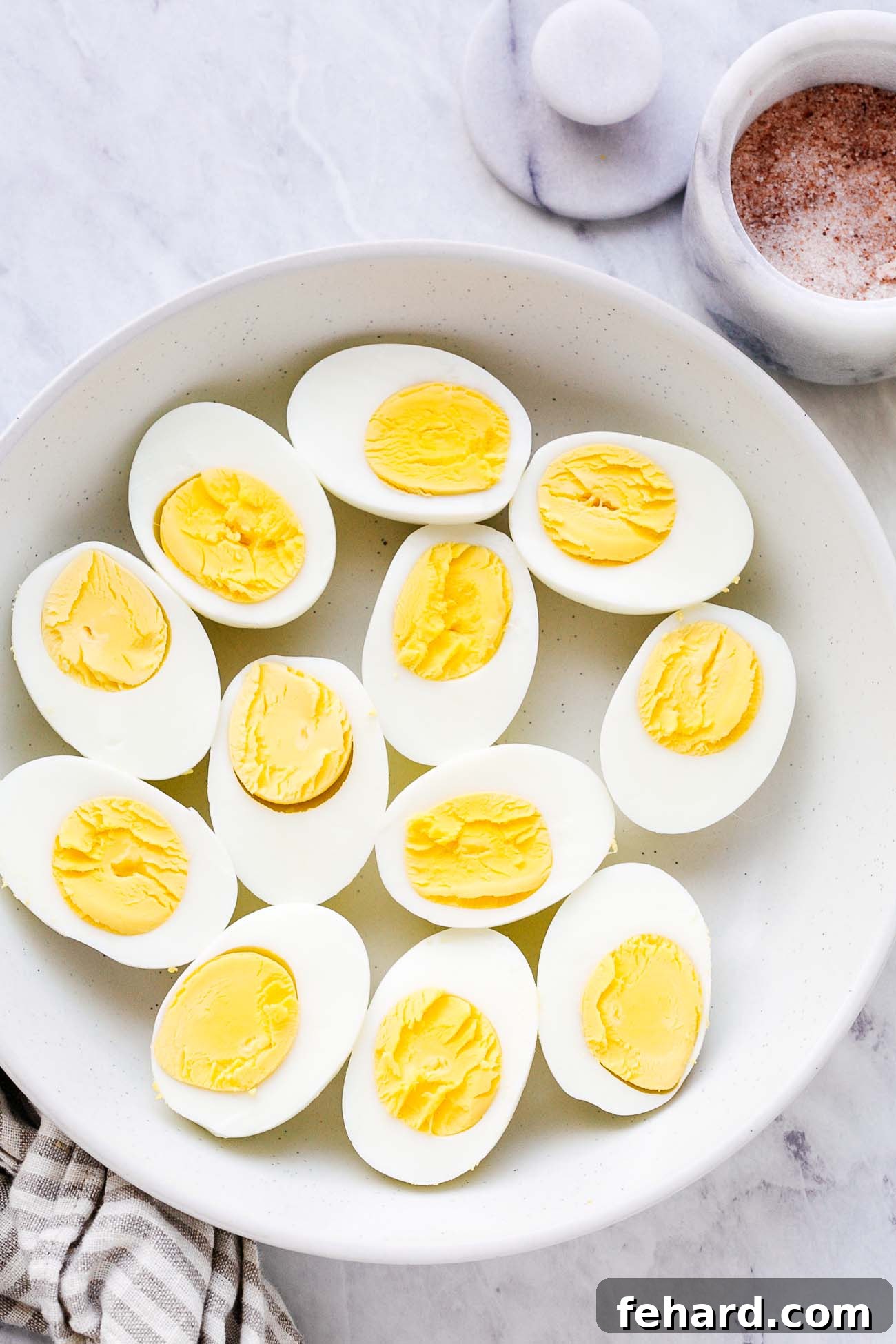 A plate of cooked eggs cut in half.