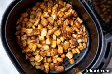 Crispy Air Fryer Potato Bites 6 Air fried cubed potatoes in air fryer basket.