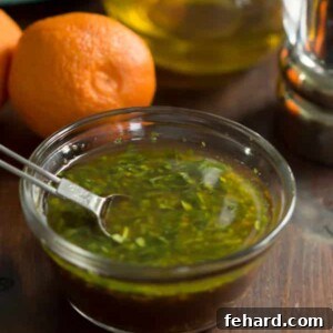 Close up view of the homemade clementine salad dressing in a small glass jar.