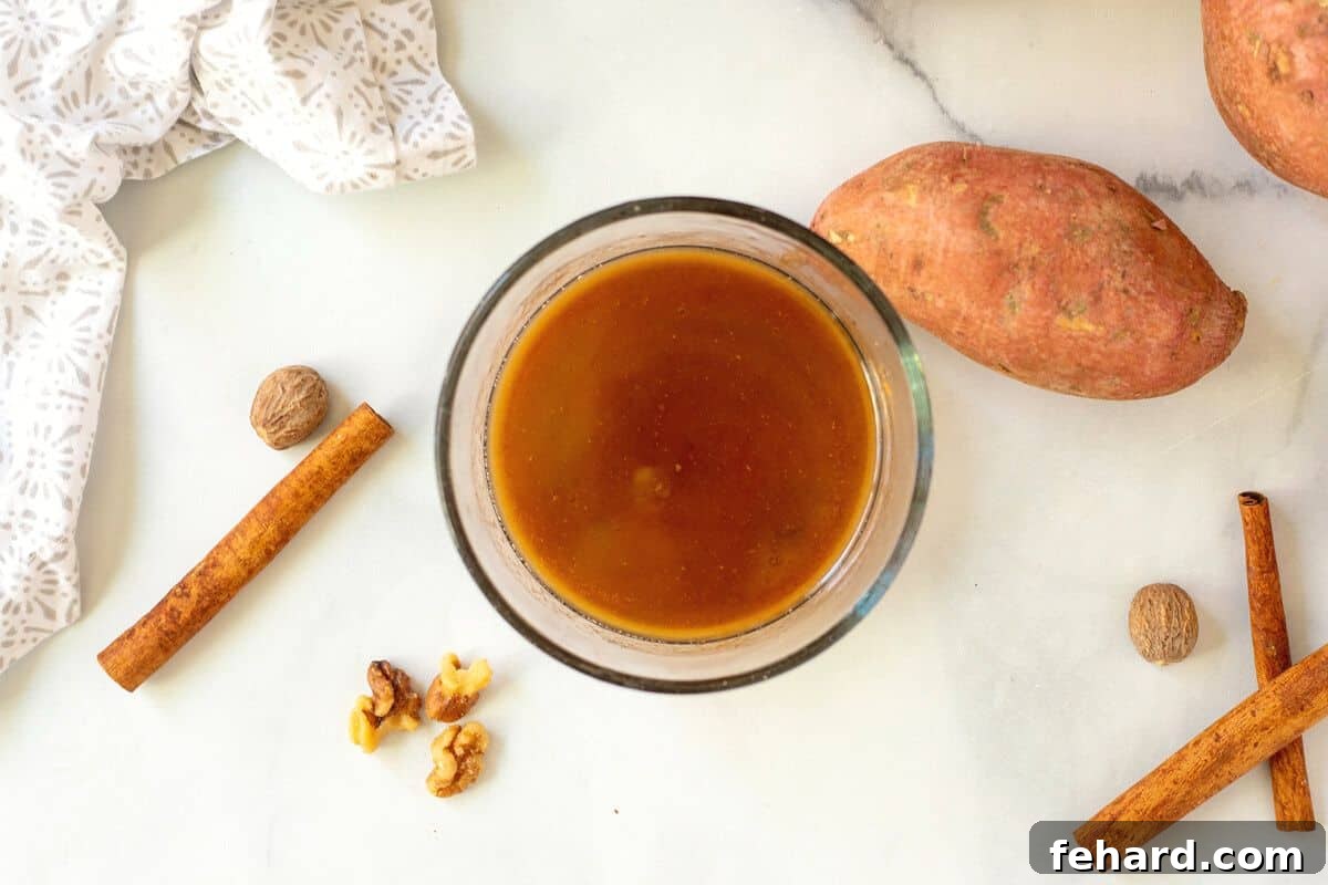 Maple Glazed Sweet Potato Glaze Maple butter glaze mixed in small mixing bowl with a whisk.