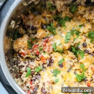 Effortless Instant Pot Burrito Bowls 4 Close up of Rice and chicken and beans with cheese in instant pot.