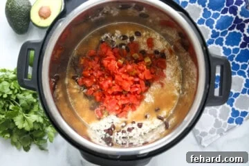Effortless Instant Pot Burrito Bowls 7 Rice, beans, chicken, and rotel tomatoes in inner pot of instant pot.