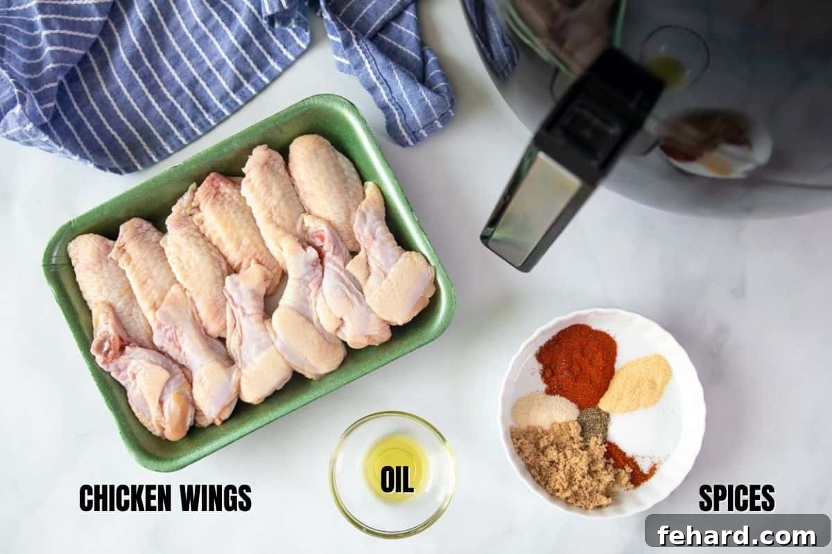 How to Make Chicken Wings Air Fryer Ingredients for chicken wings labeled on a kitchen counter: chicken wings, oil, and a bowl of dry rub spices.