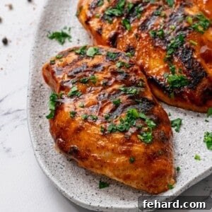 Grilled BBQ Chicken on white platter topped with parsley.