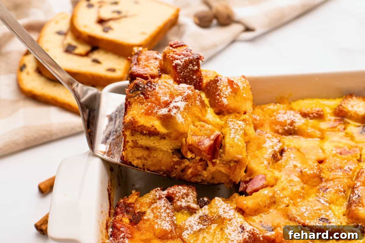 A spatula gently pulling out a generous slice of the freshly baked breakfast casserole, revealing the perfectly set eggs, tender ham, and melted cheese, ready to be enjoyed.