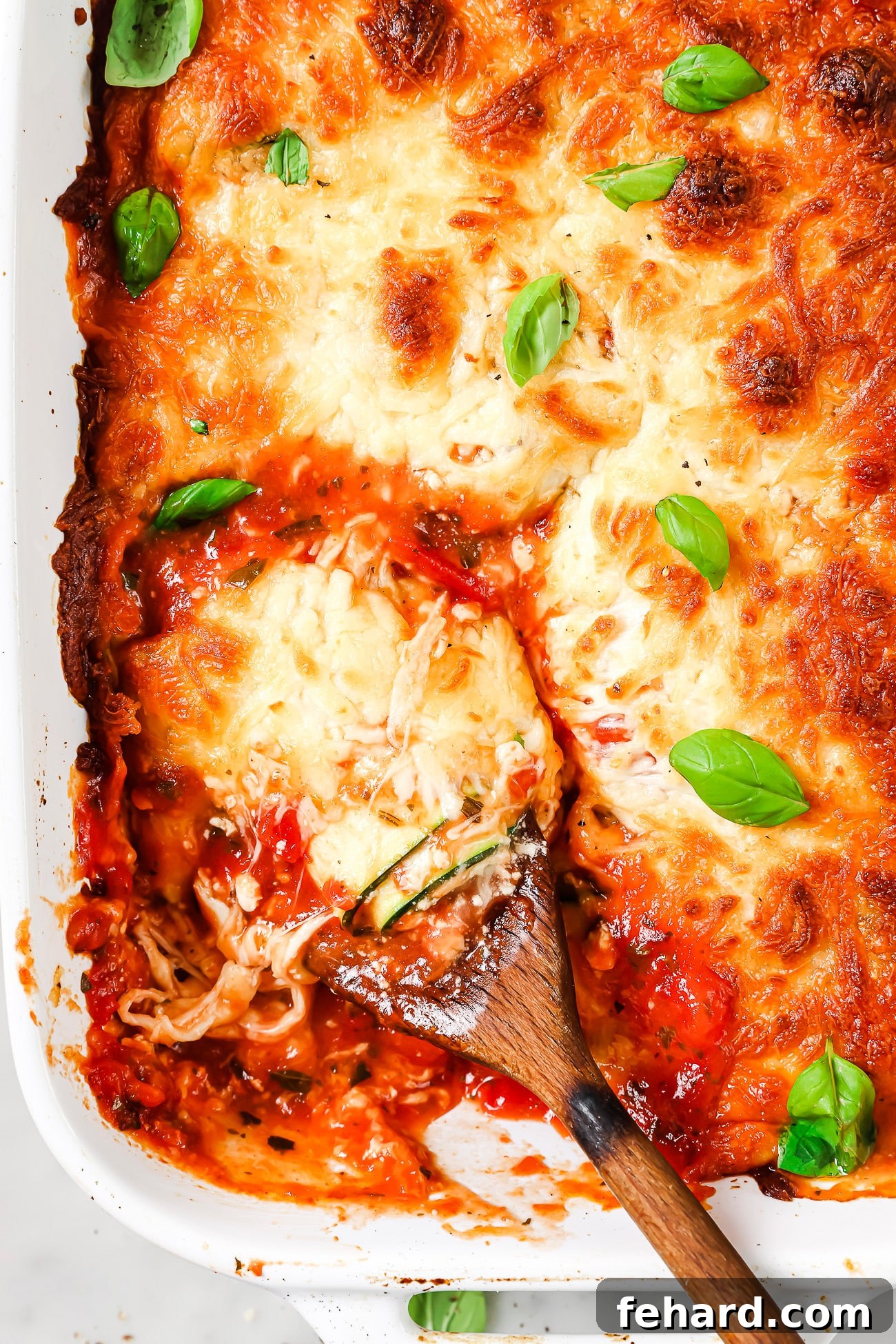 Zucchini Lasagna Pinwheels 8 An overhead view of zucchini lasagna rolls in a casserole dish, perfectly baked and ready to be served.