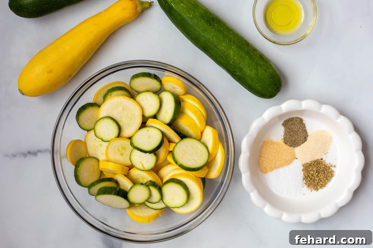 Fried Squash Air Fryer Ingredients Sliced yellow squash, zucchini, olive oil, and a selection of seasonings laid out on a kitchen counter.