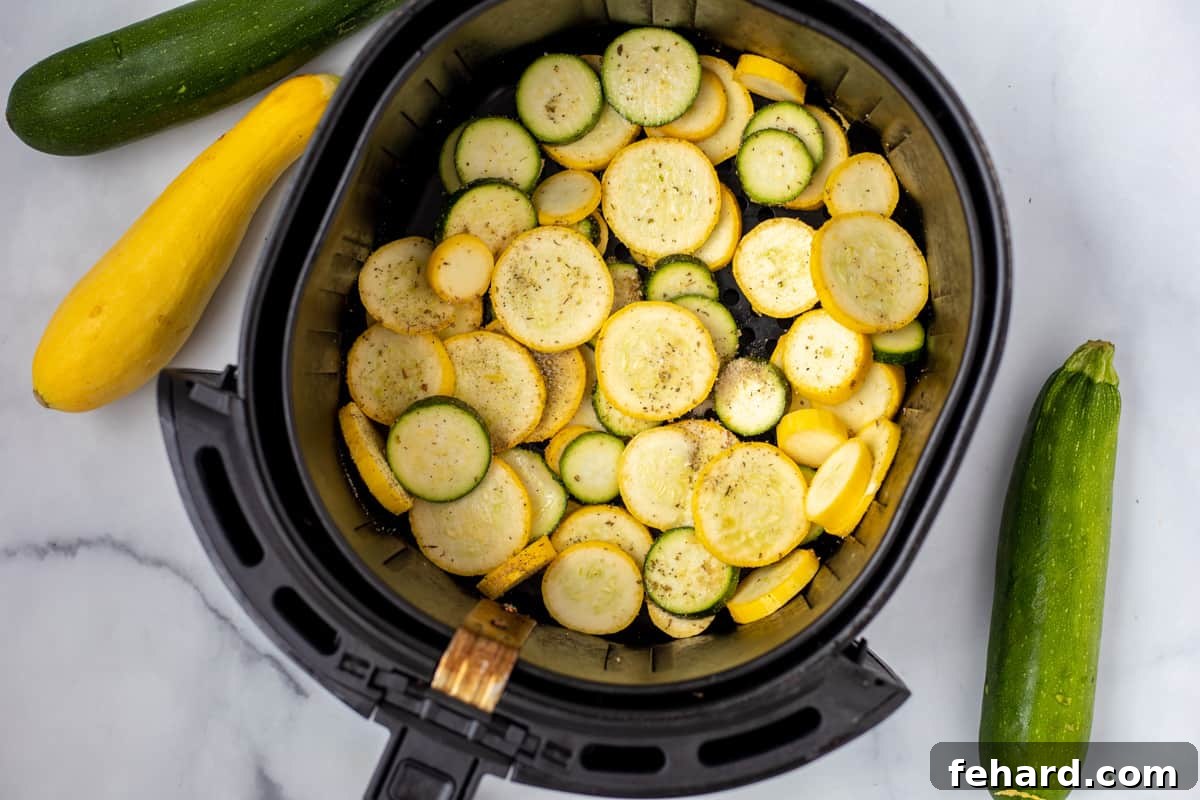 Air Fryer Fried Squash Cooking Perfectly air-fried zucchini and yellow squash in the air fryer basket, golden brown and crispy.