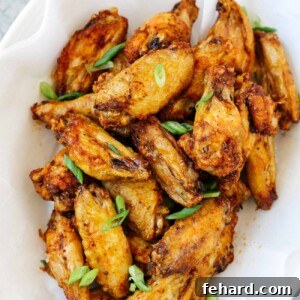 overhead view of a white plate containing cooked chicken wings