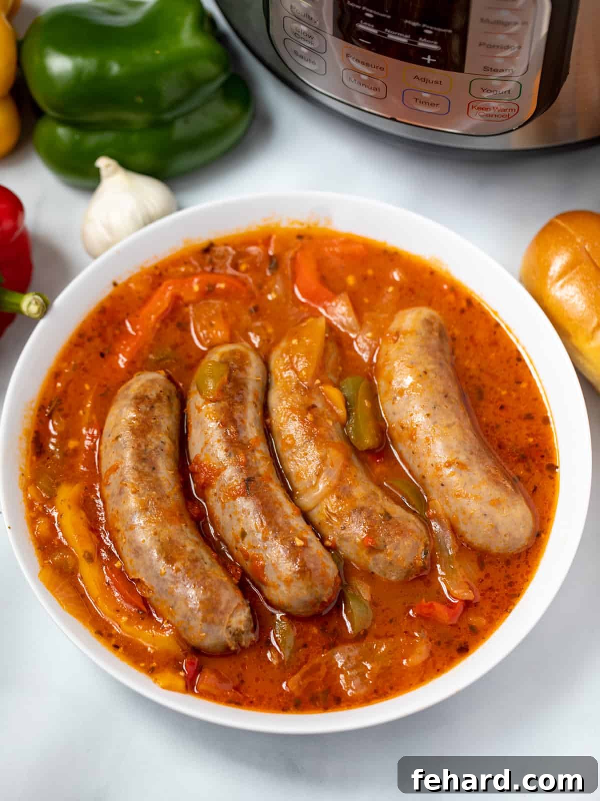 White bowl with Italian Sausage, peppers, onions, in tomato sauce next to instant pot. 