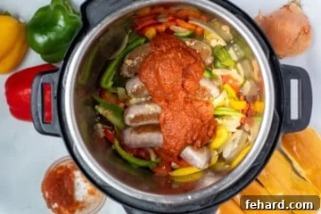 Sausage, peppers, onions, and tomato sauce layered in instant pot.
