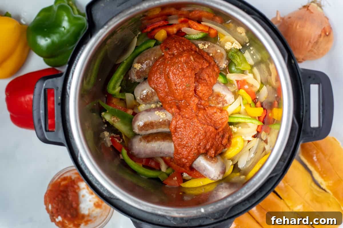 Sausage, peppers, onions, and tomato sauce layered in instant pot. 