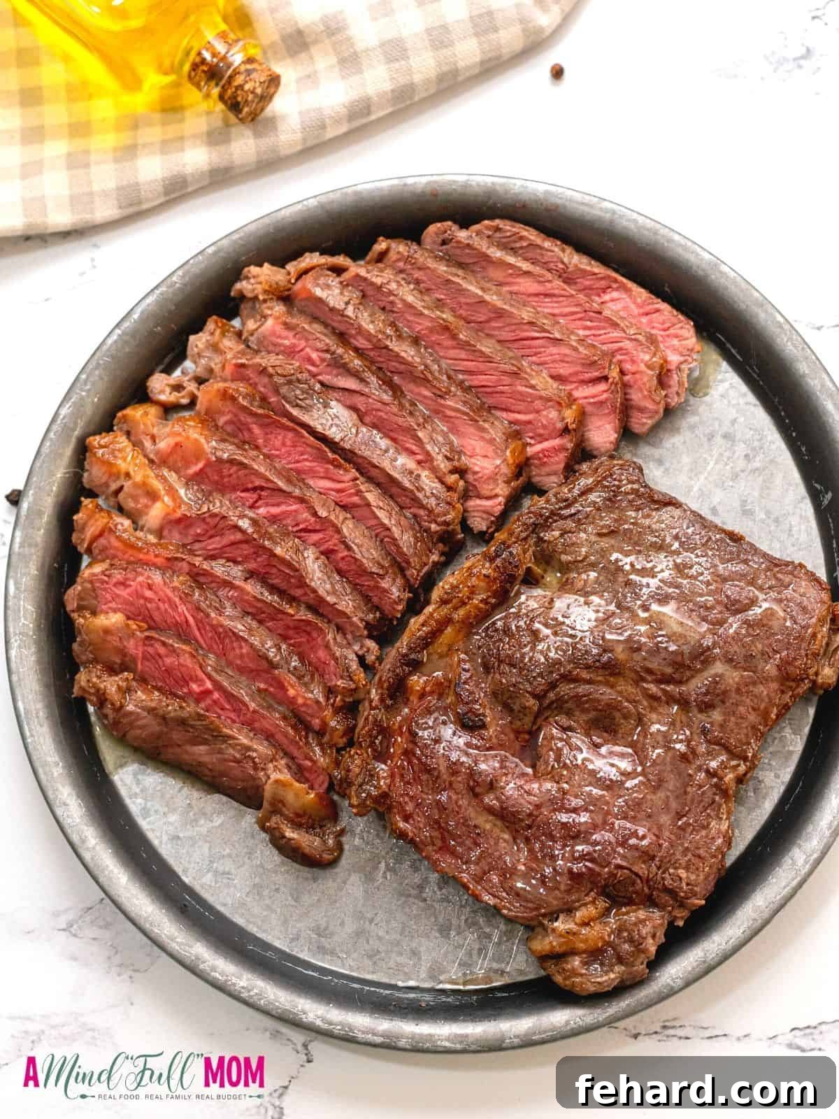 Two beautifully seared ribeye steaks on a platter; one perfectly sliced, revealing its juicy interior, next to a whole seared steak, ready to be enjoyed. The rich brown crust and tender pink center promise an exceptional dining experience.