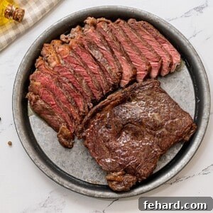 Two ribeyes on platter; one sliced, on seared.