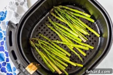 Asparagus in air fryer basket before cooking.