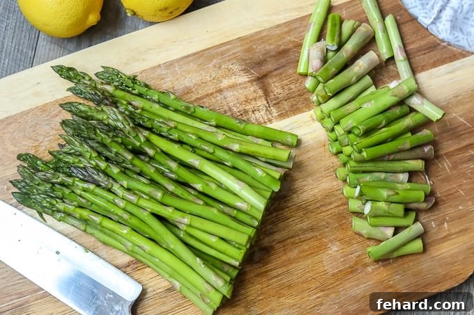 Neatly trimmed asparagus spears resting on a wooden cutting board, ready for seasoning.