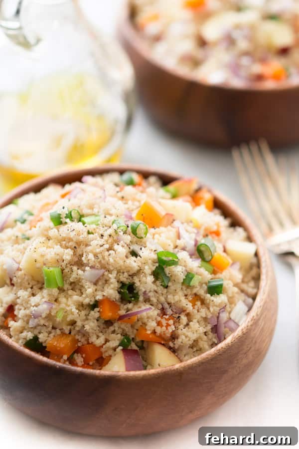A vibrant and colorful easy couscous salad served in a rustic wooden bowl, showcasing fresh chopped vegetables and herbs. Perfect for a healthy lunch or side dish.
