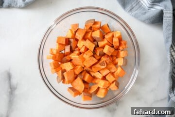 Cubed sweet Potatoes in bowl with seasonings.