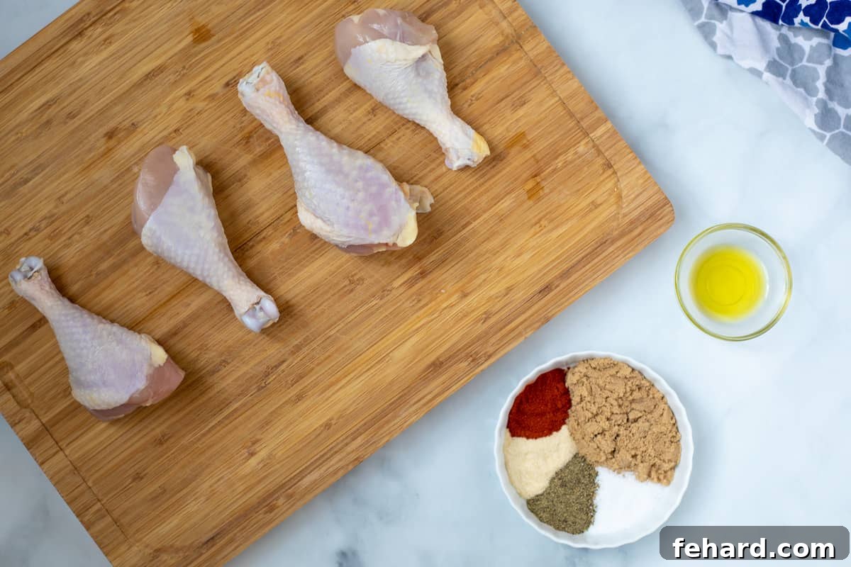 Chicken legs, oil, and dry rub ingredients laid out on a kitchen counter.