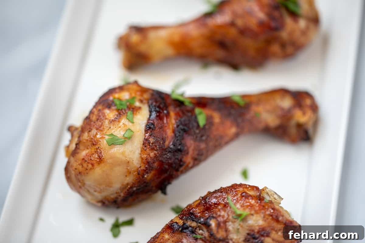 Air Fryer Chicken Drumsticks seasoned with dry rub on white platter.