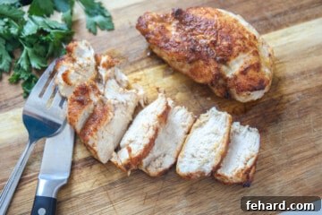 Sliced air fryer chicken breast on a wooden cutting board, showcasing its juicy texture.