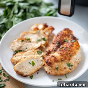 Air Fryer Chicken Breasts on white platter topped with fresh parsley.