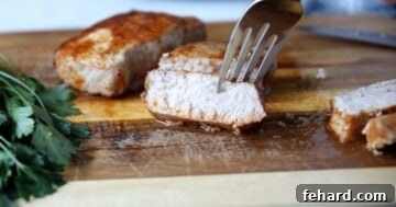 Sliced air fryer pork chops on a cutting board, ready to serve.