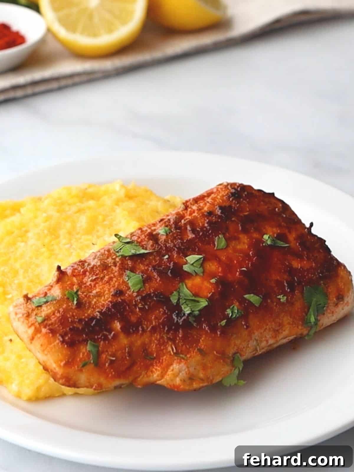 Blackened mahi mahi on white plate with cheesy grits.