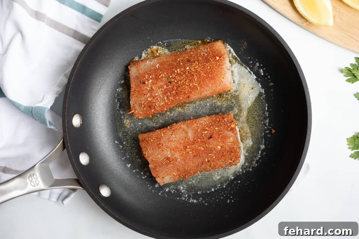Mahi mahi fillets in skillet with butter and oil.