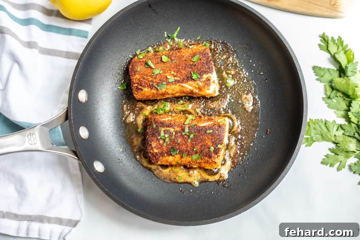 2 cooked mahi mahi fillets in skillet with parsley flakes.