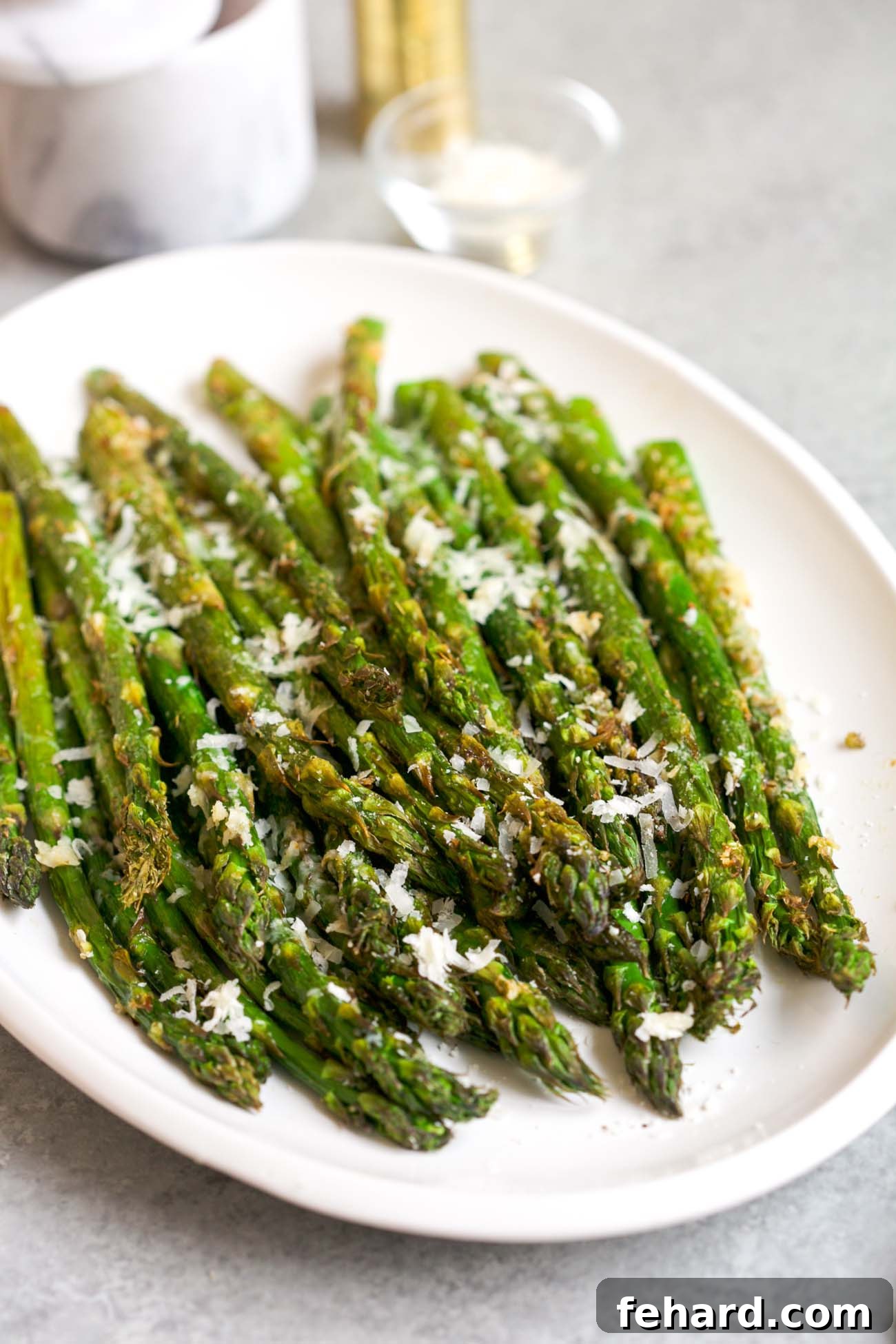 A vibrant plate of perfectly air-fried asparagus, glistening with Parmesan, ready to be enjoyed as a healthy and delicious side dish.