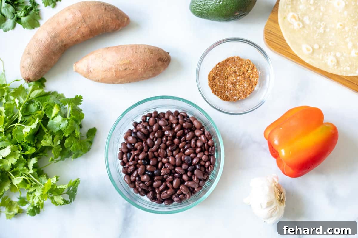 A collection of fresh and pantry staple ingredients laid out for preparing sweet potato black bean tacos, including sweet potatoes, black beans, onions, bell peppers, and spices.