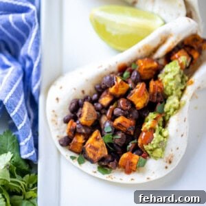 A vibrant, close-up image of a sweet potato black bean taco, perfectly arranged on a plate, ready to be served.