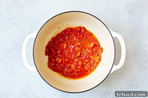 Vibrant Brazilian Fish Stew 9 overhead view of diced tomato inside of a Dutch Oven pan