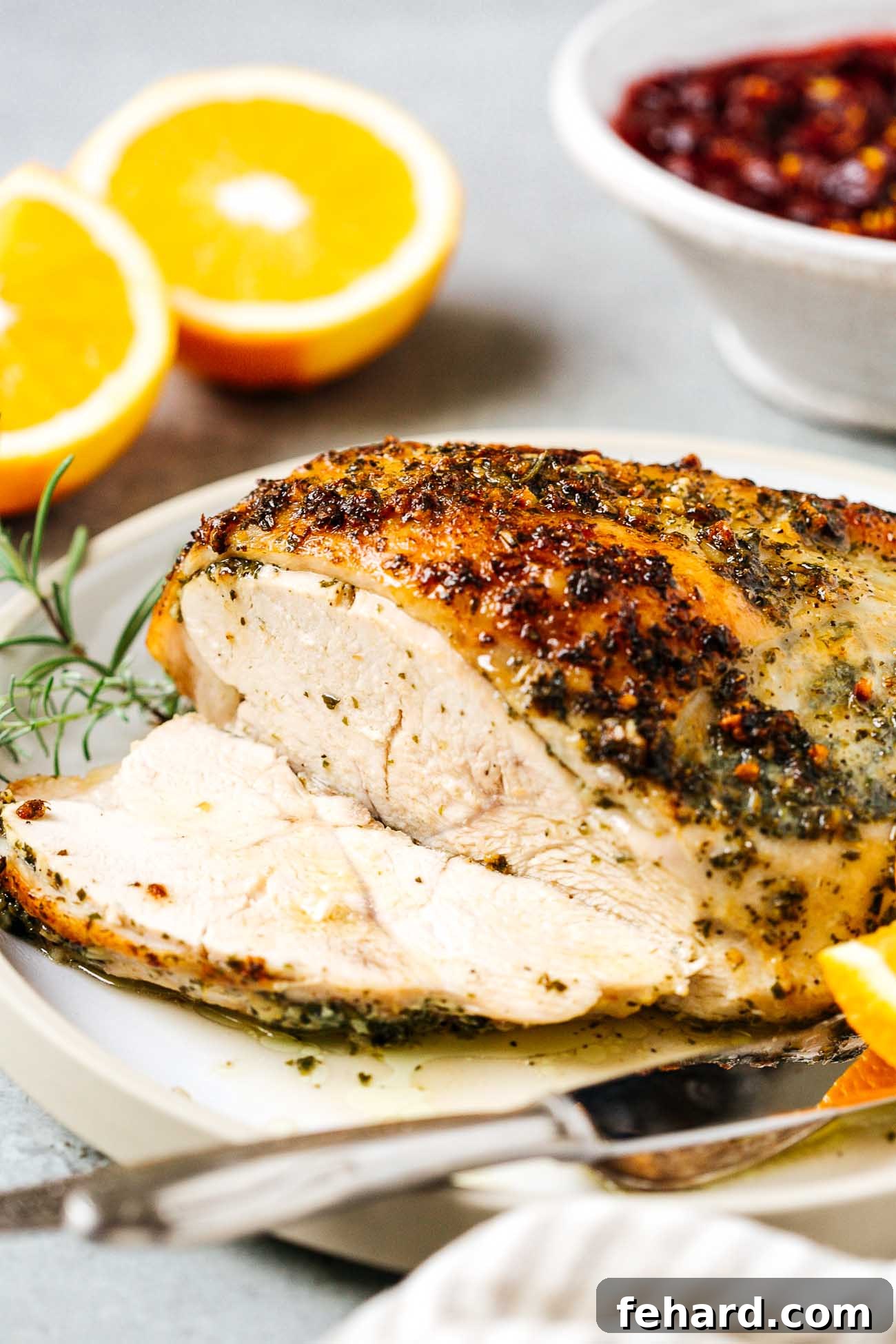 A close-up view of a sliced garlic butter turkey breast, showing its perfectly cooked, moist texture and golden skin.