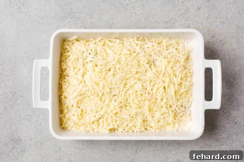 Golden Baked Cheesy Potatoes 15 overhead view of white casserole containing sliced potato, milk and mozzarella cheese