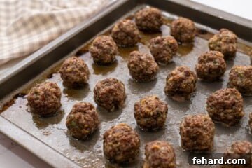 Rimmed Sheet pan with perfectly baked meatballs.