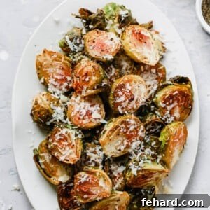 Overhead photo of a white serving platter with garlic parmesan roast brussels sprouts.