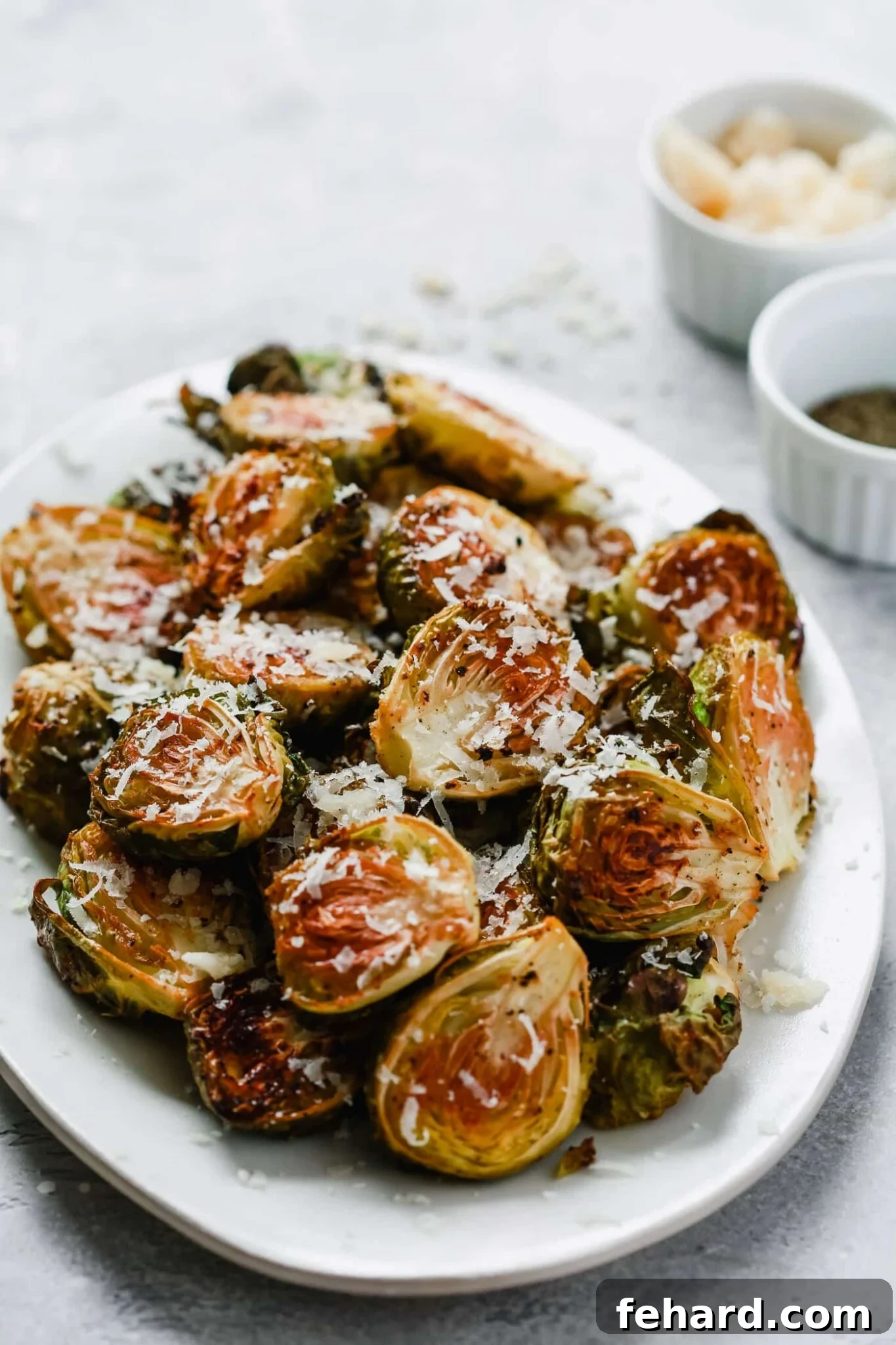closeup photo roasted Brussel sprouts on a white platter. 