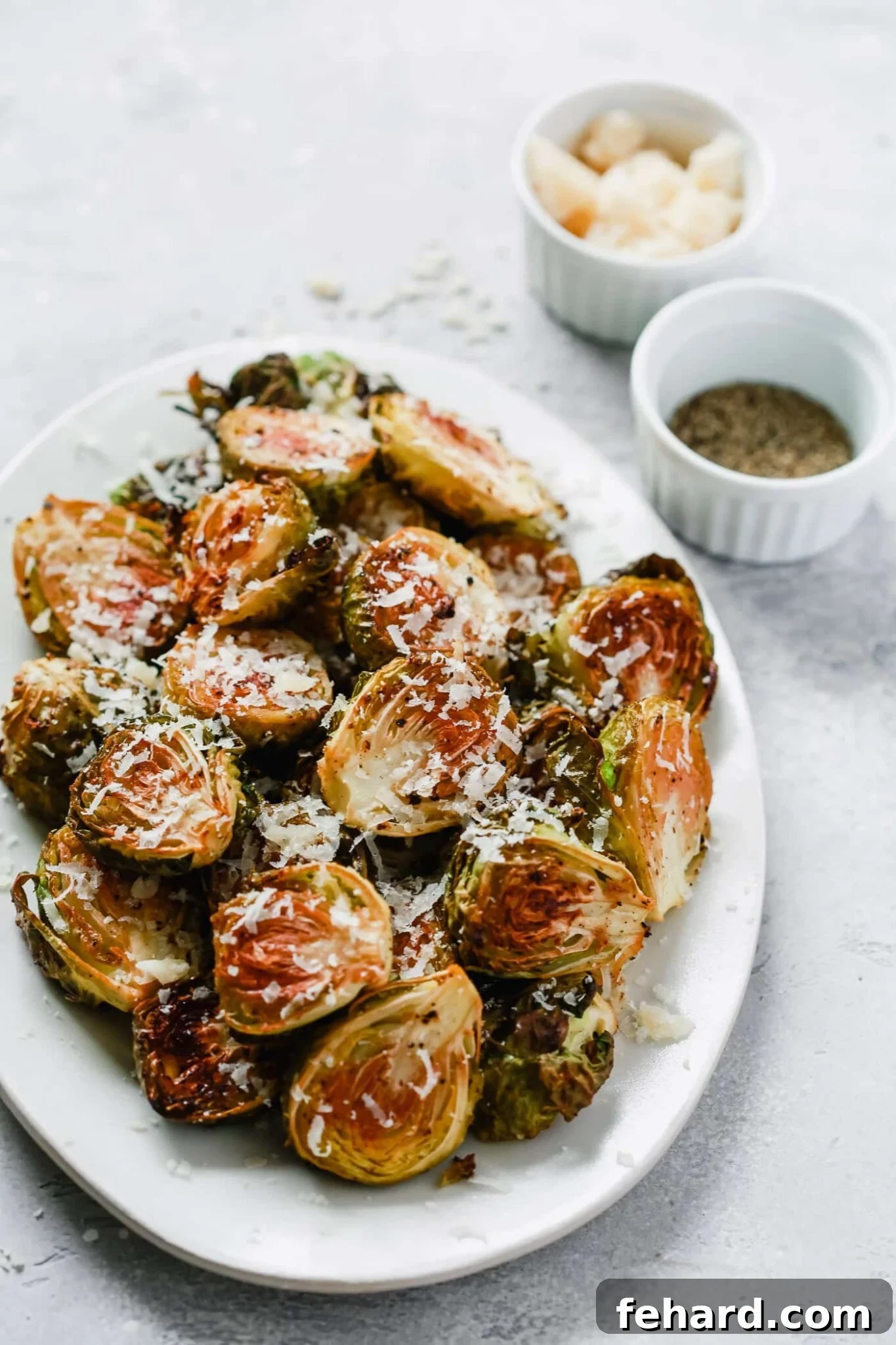 overhead view of roasted Brussel sprouts on a white platter.