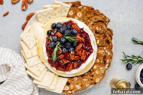 Baked Brie with Cranberry Sauce, garnished and ready to be served.