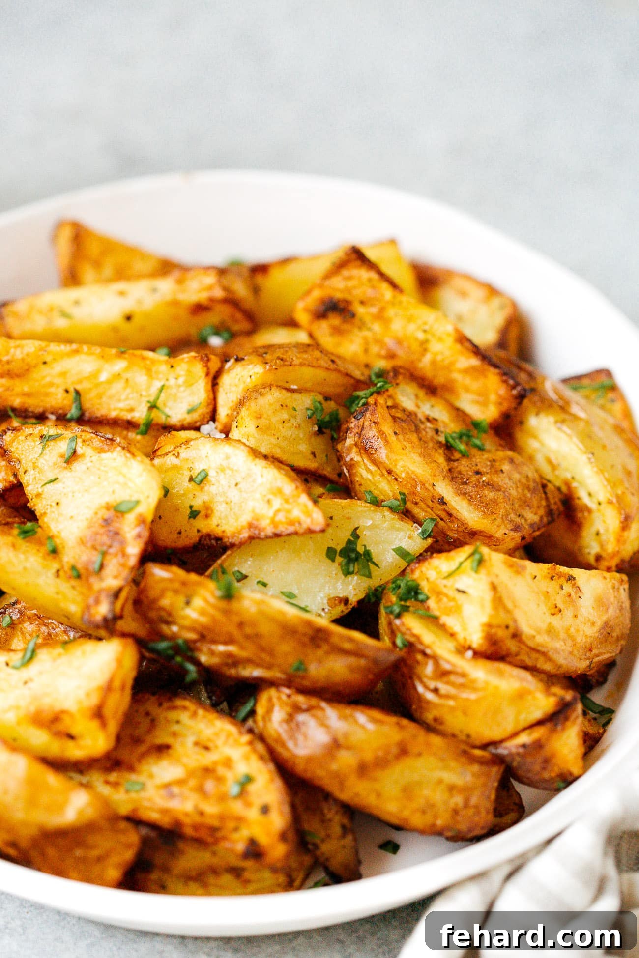 Close up of a plate of perfectly cooked potato wedges, showing their crispy texture and seasoning.