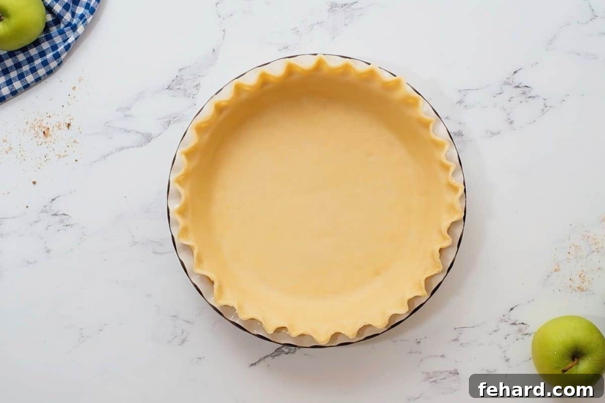 Chilled Pie Crust An unbaked pie crust, perfectly shaped and crimped, resting in a glass pie dish, ready to be filled.