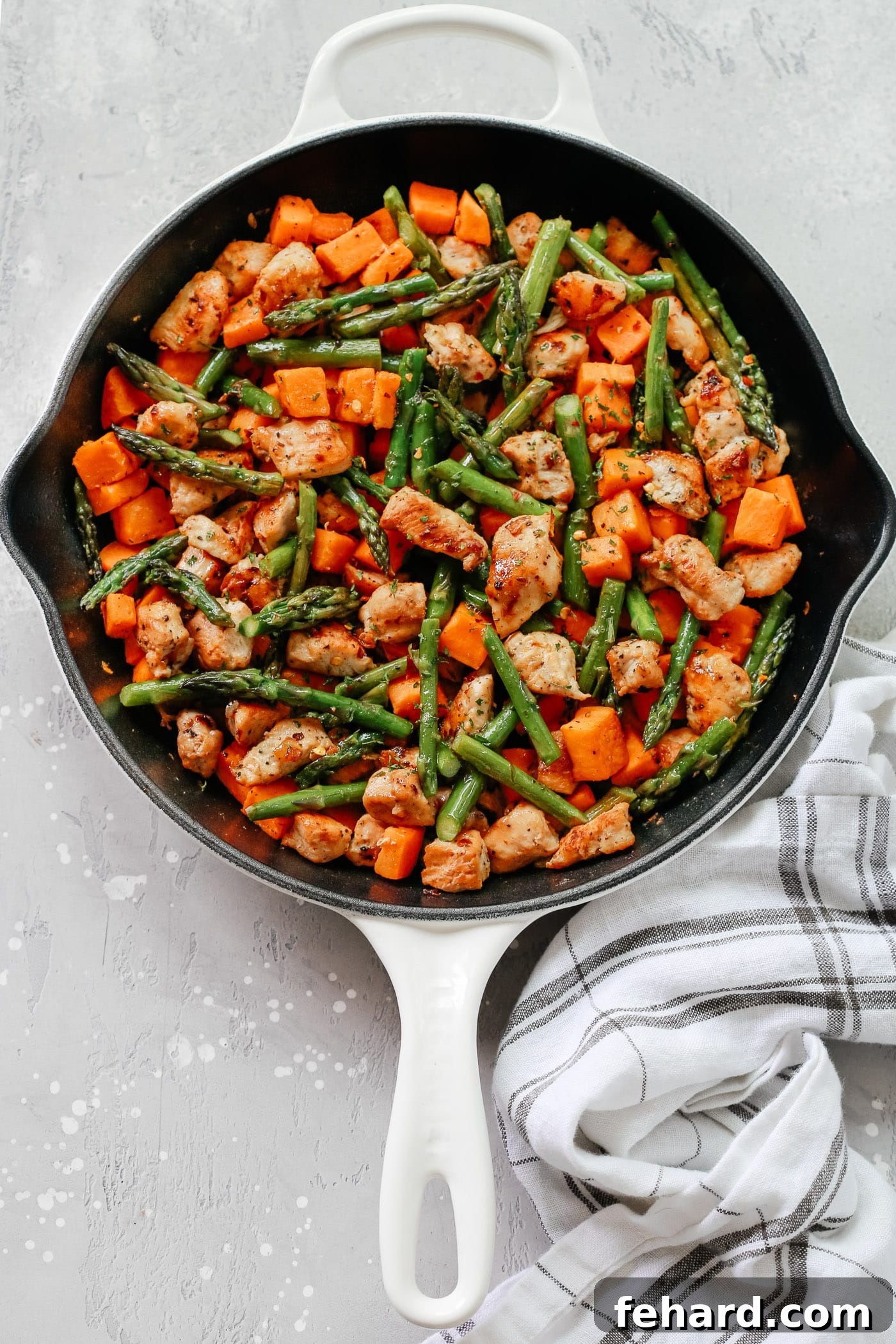 A vibrant, healthy Asparagus Sweet Potato Chicken Skillet from Primavera Kitchen, ready to be enjoyed.