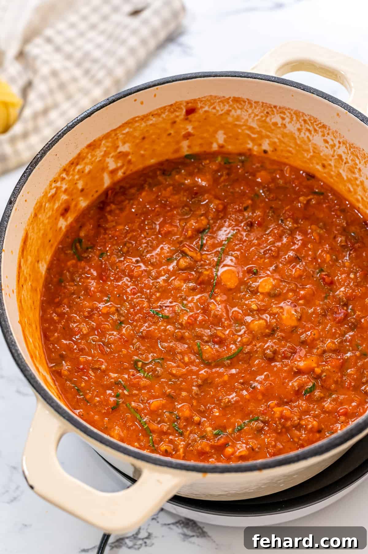 Close-up of a saucepan filled with a vibrant, homemade Bolognese sauce, rich in color and texture, ready to be served.