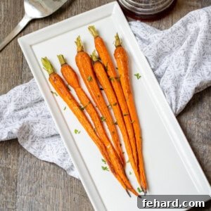 Roasted Carrots on a rustic white serving dish, garnished with fresh herbs.