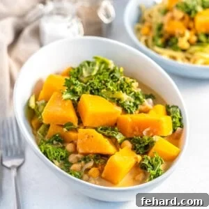 A comforting bowl of vegan butternut squash curry, rich with chickpeas and fresh kale, perfect for a wholesome meal.