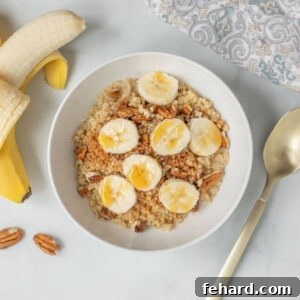 Bowl of Quinoa Porridge topped with sliced banana and pecans.