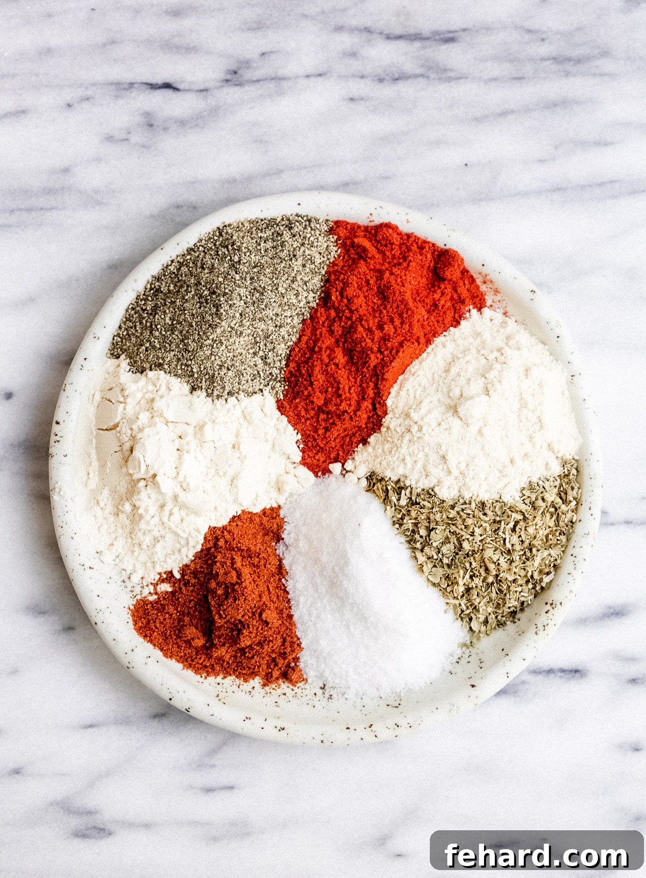 A vibrant mix of homemade Cajun seasoning spices arranged beautifully on a plate, ready to be used in cooking.