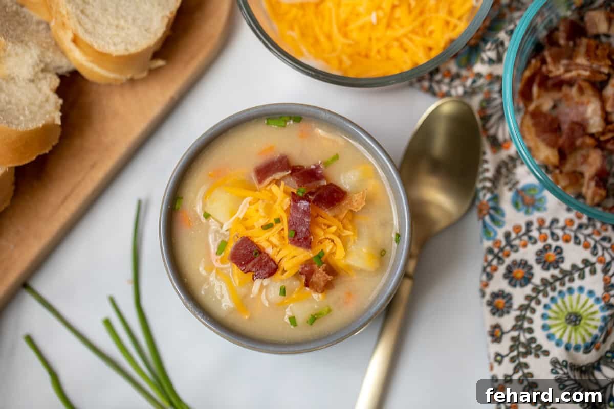Baked Potato Soup Recipe Serving A beautifully presented bowl of potato soup, generously garnished with crispy bacon, melted cheese, and fresh chives, ready to be enjoyed.